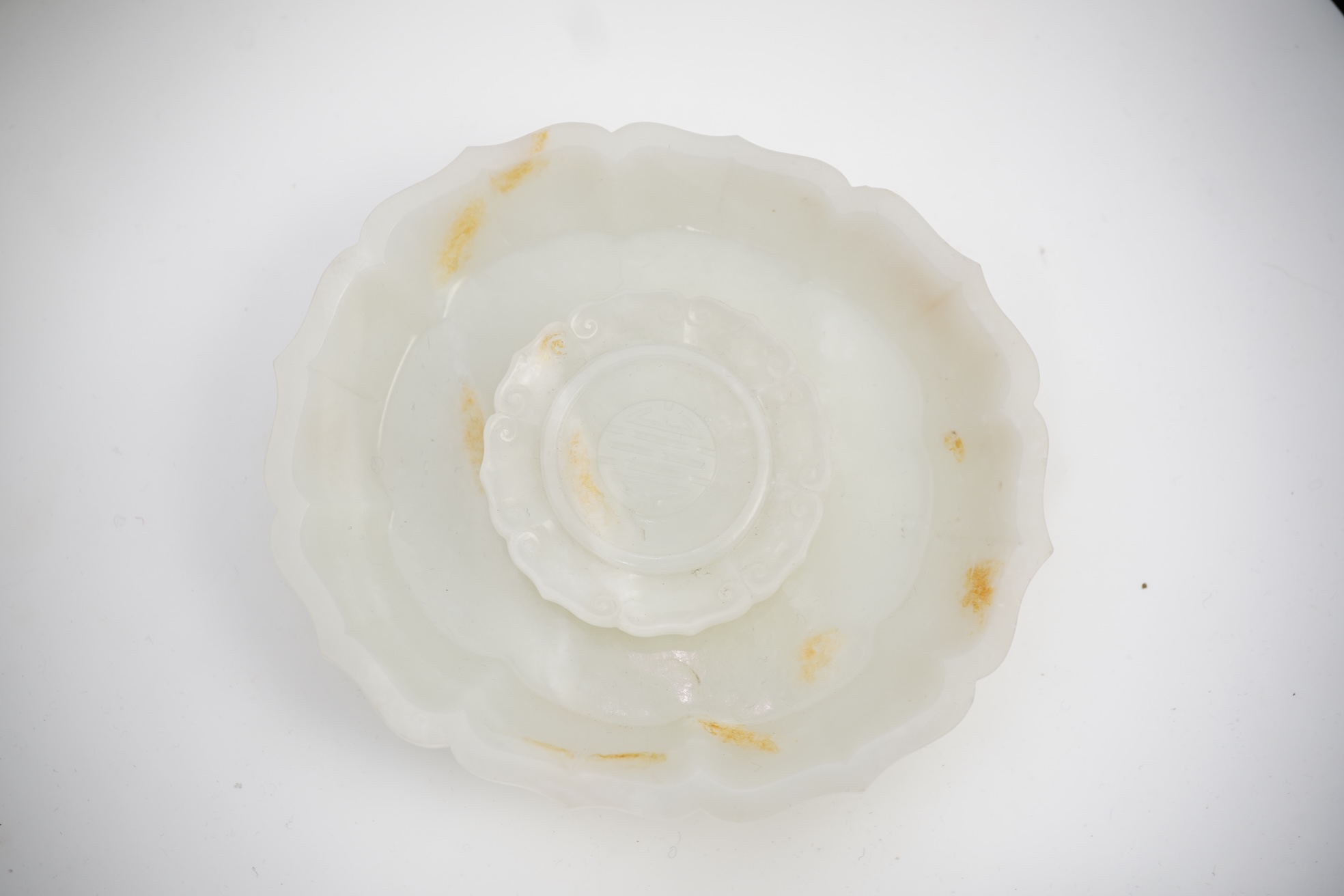 A Chinese white and russet jade petal lobed cup stand